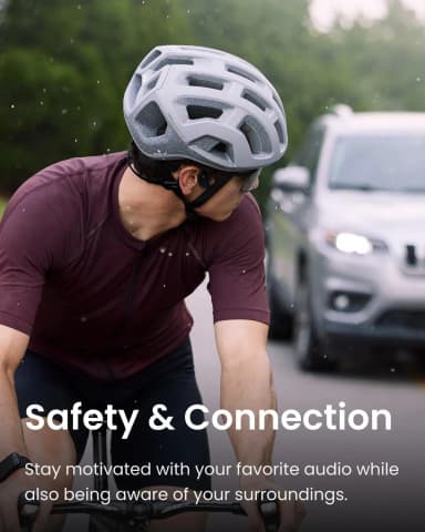 Cyclist wearing Shokz OpenRun Pro headphones, promoting safety and connection.